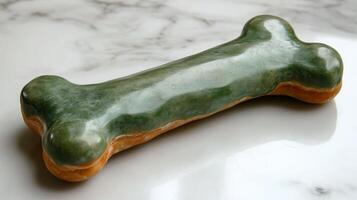 A green dog bone on a marble surface photo