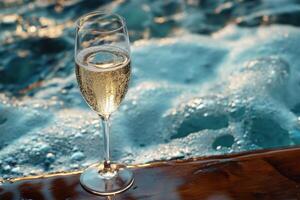 A glass of champagne on a wooden table near the ocean photo