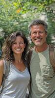 A man and woman are smiling while standing in front of trees photo