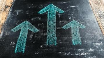 Chalkboard with arrows pointing upward on a wooden table photo