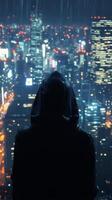 A person in a hoodie looking out over a city at night photo