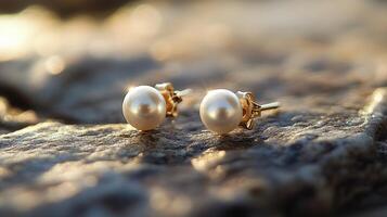 A pair of pearl stud earrings on a rock photo