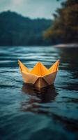 A paper boat floating in the water photo