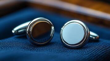 Two silver cufflinks with a white circle on them photo