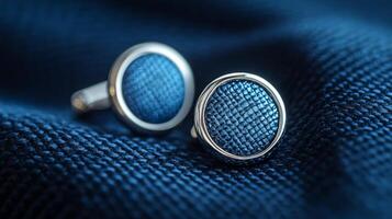 A pair of blue cufflinks on a blue cloth photo