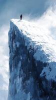 A man standing on top of a mountain with snow photo