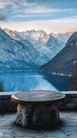 A stone table sitting in front of a lake and mountains photo