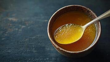 A spoon is in a bowl of honey photo