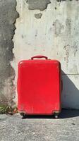 A red suitcase sitting on the ground photo