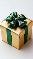 Gold gift box with green ribbon and bow photo