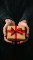 A person holding a gift wrapped in brown paper photo