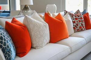A couch with orange and white pillows photo