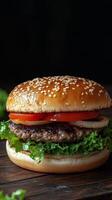 A hamburger with lettuce and tomato on a wooden table photo