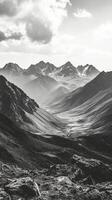 Majestic mountain range with rugged peaks and deep valleys during misty daylight photo