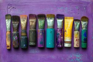 A group of paint brushes on a purple background photo