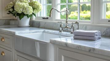 A white kitchen sink with a window and flowers photo