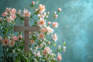 A wooden cross is placed in front of pink flowers photo