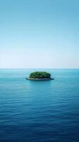 Lush green island surrounded by calm blue ocean under a bright sky with scattered clouds photo