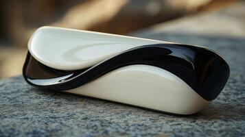 A black and white purse sitting on a stone surface photo