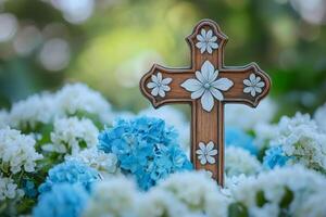 Wooden cross surrounded by delicate pink flowers on a soft blue background during daytime photo