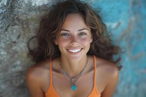 A woman in an orange top smiling photo