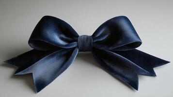 A dark blue velvet bow on a white surface photo