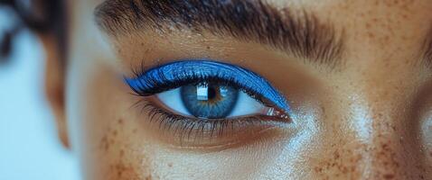 Bright blue eyeliner highlights stunning eye features in close-up portrait of a model photo