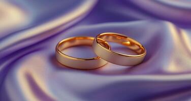 Elegant golden wedding rings resting on smooth purple fabric at a romantic gathering photo