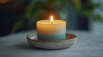 A candle is lit on a ceramic bowl photo