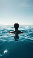 Calm swimmer enjoying the serene blue waters under a clear sky at midday photo