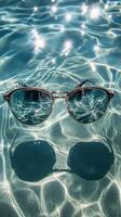 A pair of sunglasses floating in a pool of water photo