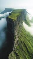 A green mountain with clouds and grass photo