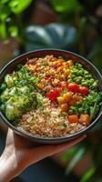 A person holding a bowl of food with vegetables and rice photo