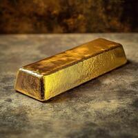 A shiny gold bar sits upon a textured surface photo