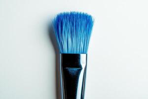 A blue makeup brush on a white surface photo
