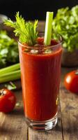 A glass of tomato juice with celery and fresh herbs photo