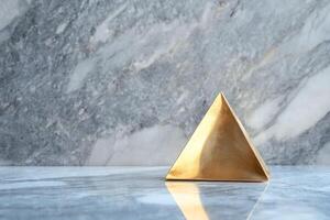 A gold pyramid shaped object on a marble counter photo