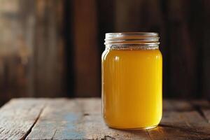 A jar of liquid sitting on a wooden table photo