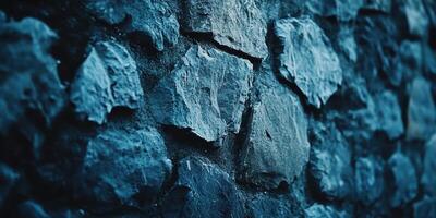 An array of dark blue and gray cobblestones form a wall photo