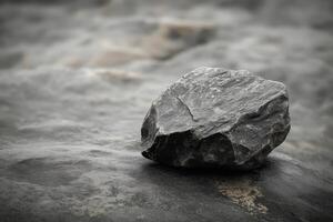 Single grey rock rests on a textured surface photo
