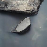 Large rocks partially submerged in a calm body of water photo