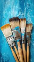 Five paint brushes on a blue background photo