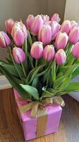 A pink box with white and pink tulips in it photo