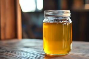 A jar of honey sitting on a wooden table photo