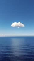 A lone cloud floating in the middle of the ocean photo
