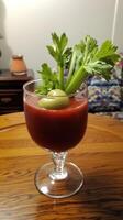 A glass of bloody drink with celery garnish photo