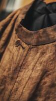 Close up of a brown shirt with a button photo