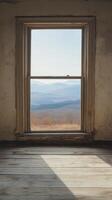 An empty room with a window looking out over a mountain photo
