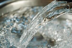 A close up of water being poured into a metal bowl photo