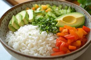 A bowl of rice, avocado, and vegetables photo